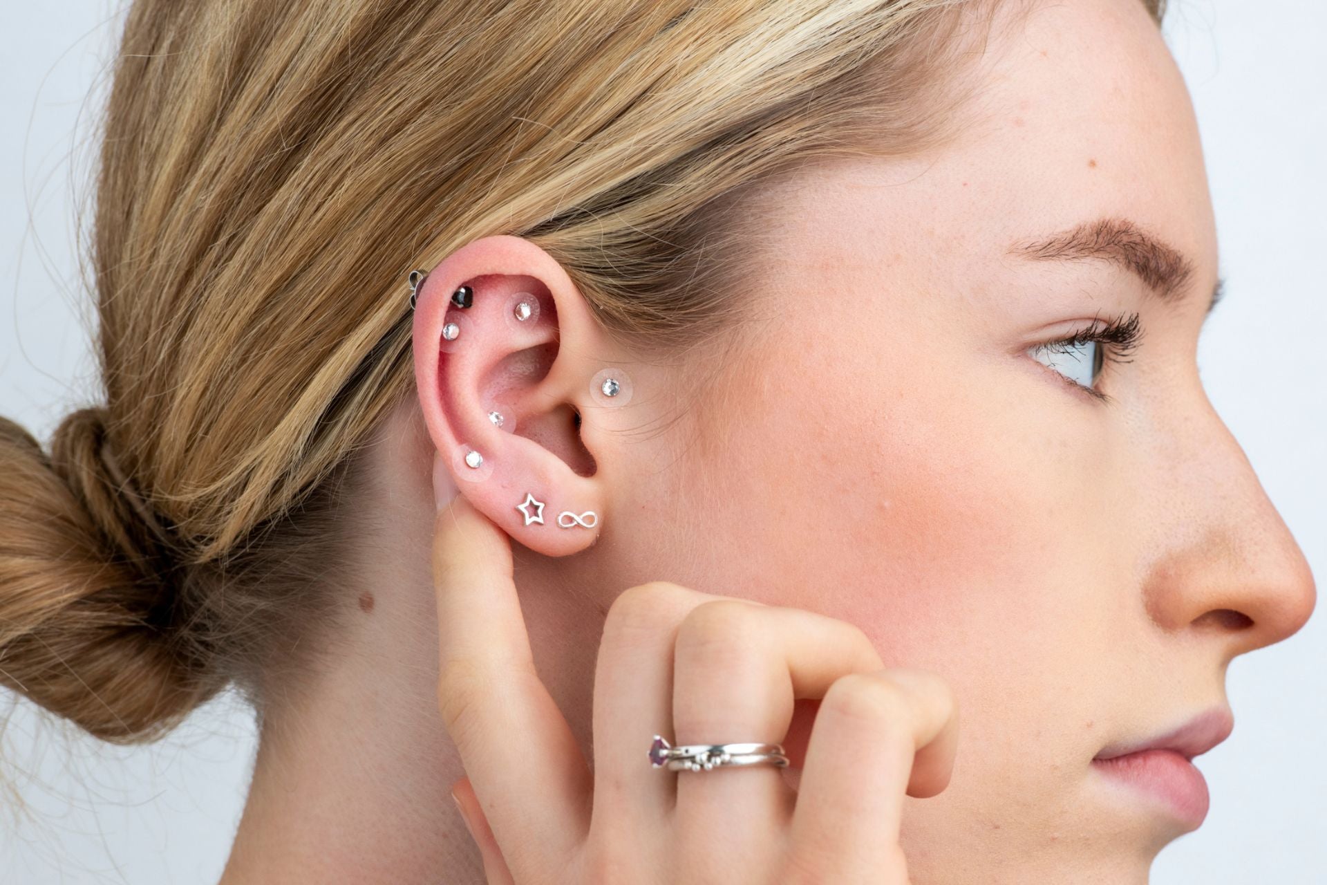 A women wearing silver crystal ear jewellery & crystal acu ear seeds.